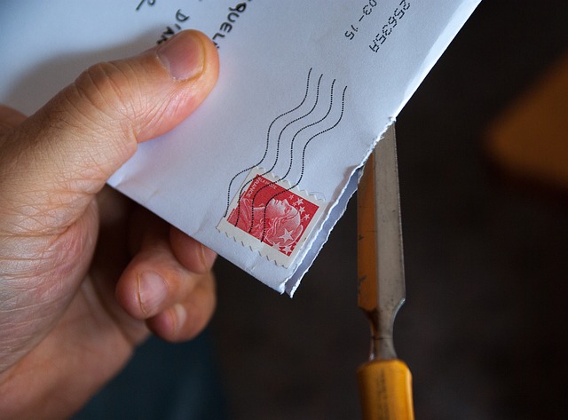 Person holding an envelope with a stamp on it